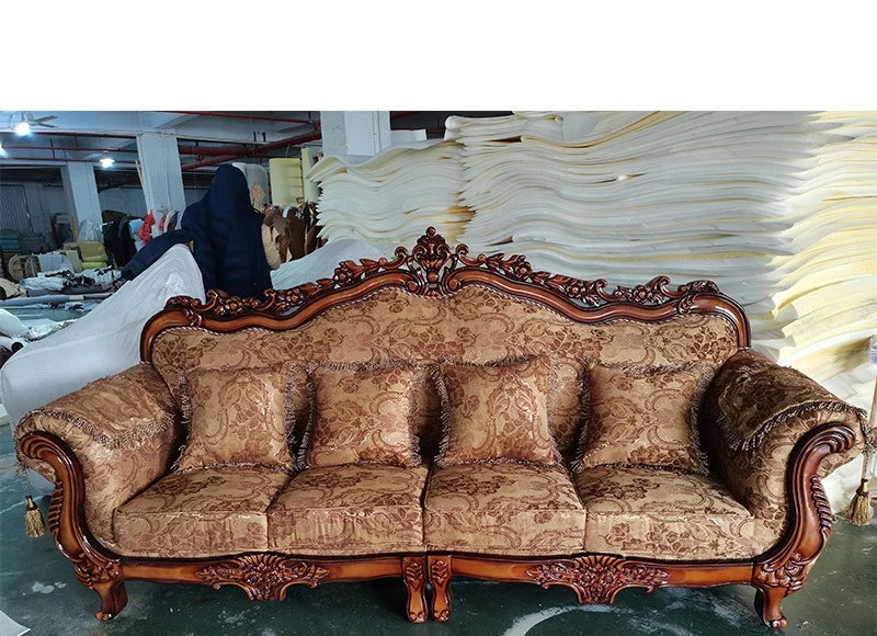 Decorative sofa with intricate woodwork in a warehouse setting