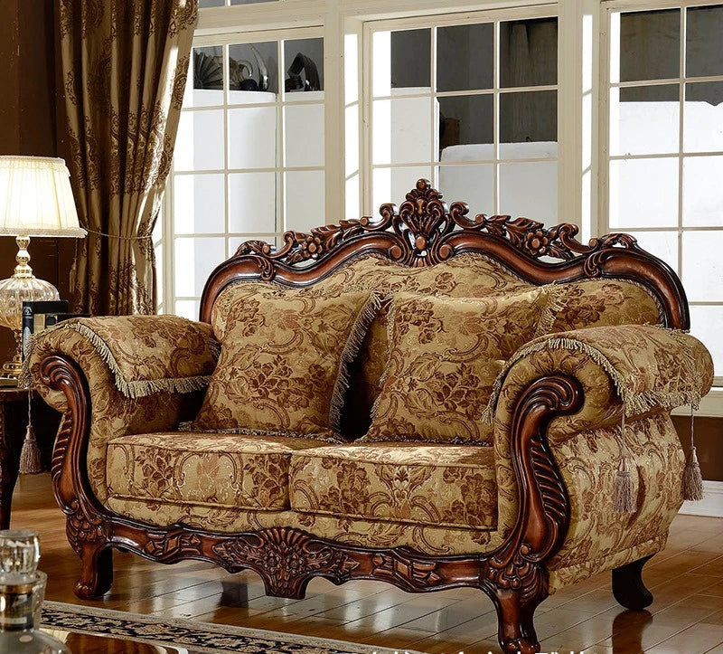 Decorative sofa with intricate woodwork and patterned fabric in a room with large windows.