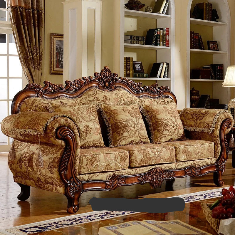 Decorative sofa with intricate carvings in a room with bookshelves.